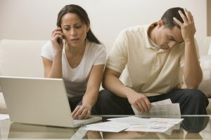 Hispanic couple having difficulty paying bills. - JDRF